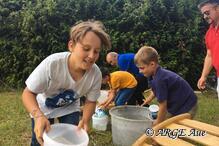 Kinder-Teams beim Beladen der Schubkarren.